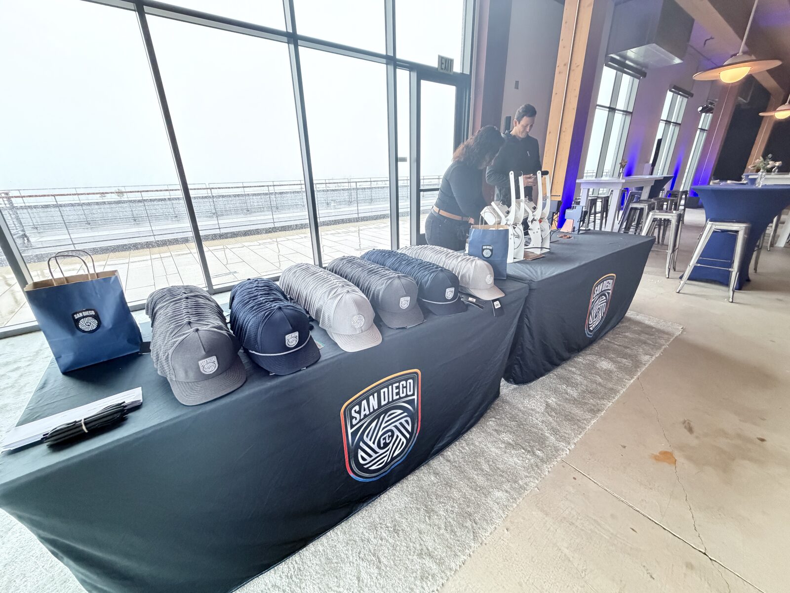 Row of finished branded caps from a San Diego event hat bar